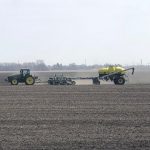 This agronomic image shows a tractor planting wheat.