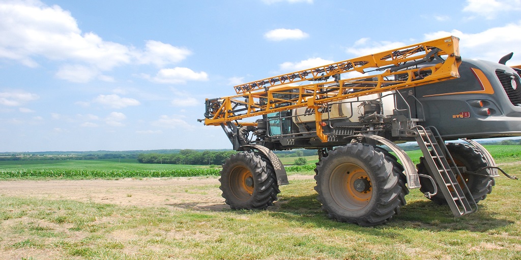This agronomic image shows a sprayer on corn fields.