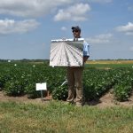 This agronomic image shows Seedcare Specialist Clay Koenig explains the value in treating soybean seeds with a visual aid at our Columbia, MO, Grow More Experience site.
