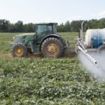 soybean field being sprayed with a pesticide